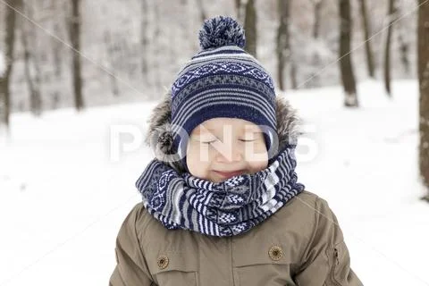 Child in winter, portrait squint blink Stock Photos