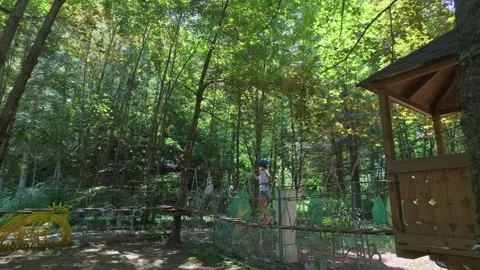 Child on wooden platform, ready for zip line Stock Footage 341768020