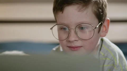 Child works at computer. Close-up of boy face in big glasses who is looking Stockbeeldmateriaal 307170673