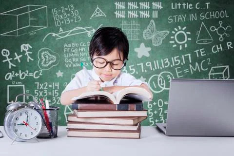 Child writes on the book in class Stock Photos