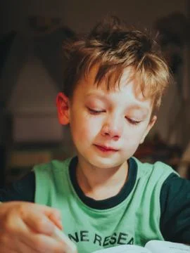 Child writes lessons, distance learning. reluctant to write lessons Stock Photos