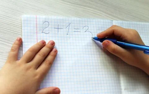 Child writes math in the notebook Stock Photos