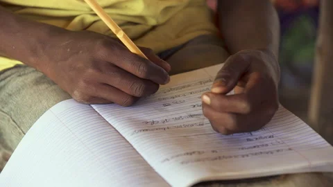 A child writes in a notebook in an African school Stock Footage 257461893