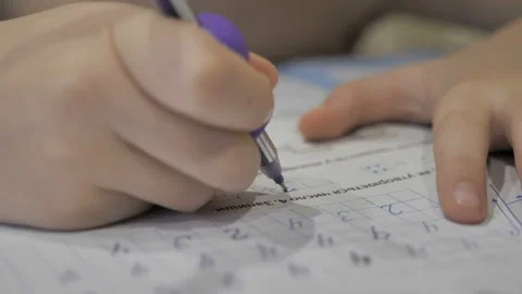Child writes the numbers in school notebook. Stock Footage 122755510