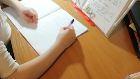 The child writes on a sheet of paper, at the desk, the education of children Vídeo Stock 88459615