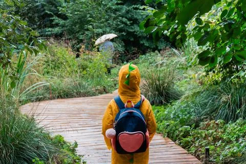 Child In Yellow Raincoat Walking Through Forest Trail Foto stock