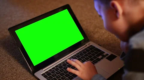 Child (young boy) works on notebook - closeup laptop - green screen Stock Footage 49855645