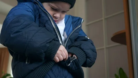 child putting on coat