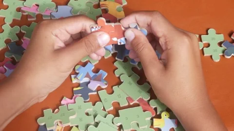 Child&amp;#039;s hands playing with a jigsaw puzzle. Educational concept Stock Footage 321979166