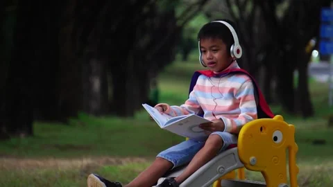 Childen sitting in the park studying Stockbeeldmateriaal 221698538