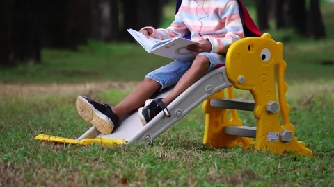 Childen sitting in the park studying Stock Footage 221698547