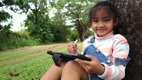 Childen sitting in the park studying 動画素材 221703508