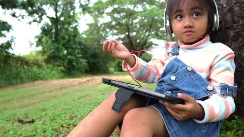 Childen sitting in the park studying Видео 221703579