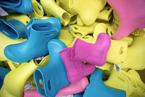 Childlike multi-colored rubber boots in the store . Top view Stock Photos