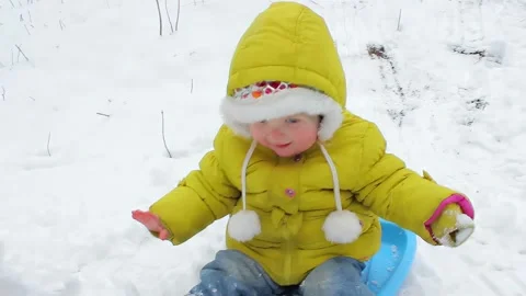 Childon sleds laughingly slide down a snow slide Video stock 292679083