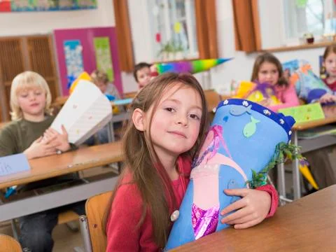 Children (4-7) in class room, holding school cones Stock Photos