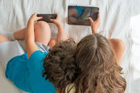 Children absorbed in screen time on digital devices Stock Photos