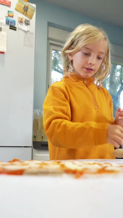 Children adding the ingredients for a homemade pizza Stock Footage 255376820