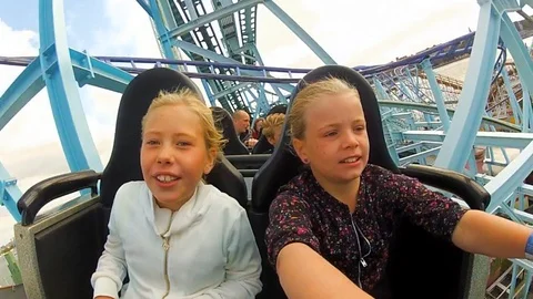 Children and enjoy riding a rollercoaster at high speeds in an amusement Stock Footage 103121069