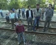 Children and men standing on train tracks looking at camera SD Footage
