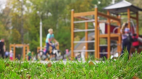 Children and parents having fun on playground in park, slow motion. Stock Footage
