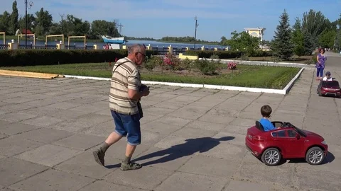 Children and their parents riding electric cars Stock Footage