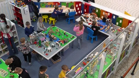 Children are busy playing with blocks while their parents are shopping. Stock Footage 323257989