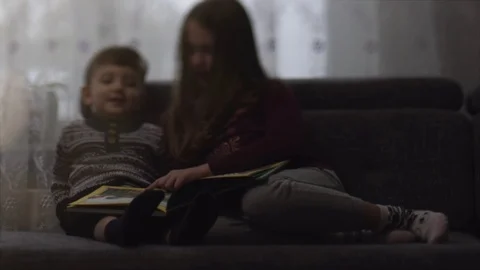 Children are considering a book . Blurred movie 스톡 동영상 101806978