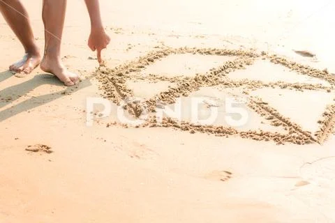 Children are drawing on sand. Stock Photos