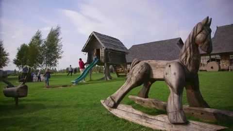 Children are having fun in the old-fashioned playground, wooden rocking horse Stock Footage 248846599