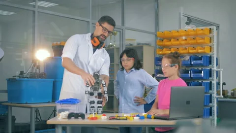 Children are observing a functioning robot in hands of a lab worker Video stock 94943955