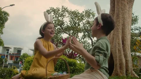 Children are painting Easter eggs. Easter Egg Hunt. Children with bunny ears on Stock Footage 305942403