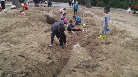 The children are playing and digging sand pits Stock Footage 301178600