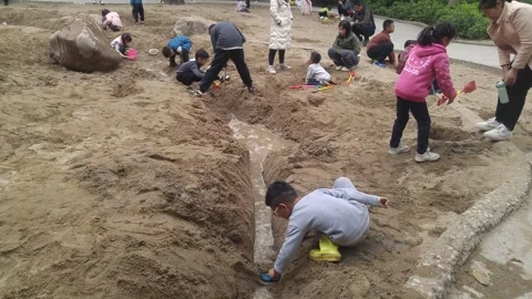 The children are playing and digging sand pits Stock Footage 301178986