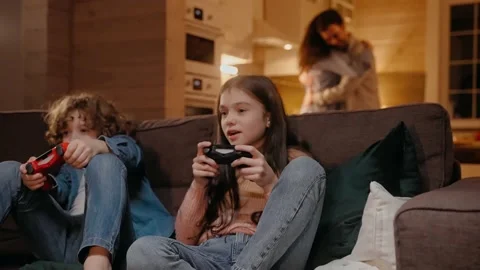 Children are playing on game console, parents are dancing at the background Vídeo Stock 165411426
