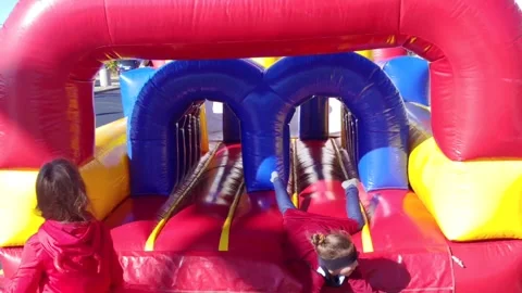 Children are playing on an inflatable in the park Stock Footage 213196639