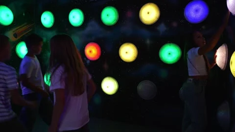 Children are playing a logic game by clicking on the buttons on the wall. Stock Footage 323911590