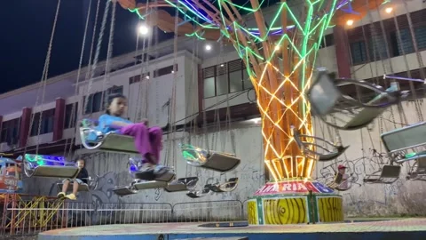 Children are playing mini swing ride with friends in a playground 스톡 동영상 347543644