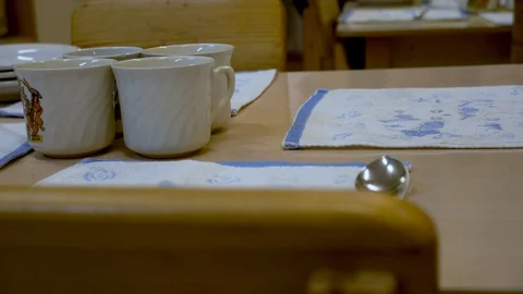 Children are preparing for dinner in kindergarten. Tea mugs close-up Stock Footage 99729329