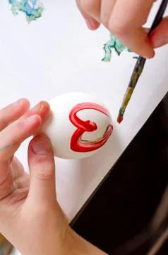 Children are preparing for Easter. Coloring eggs with brushes and multi-color Stock Photos