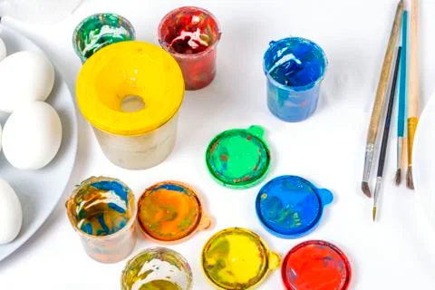 Children are preparing for Easter. Coloring eggs with brushes and multi-color Stock Photos