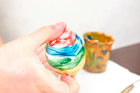 Children are preparing for Easter. Coloring eggs with brushes and multi-color Stock Photos
