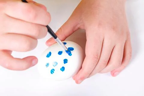 Children are preparing for Easter. Coloring eggs with brushes and multi-color Stock Photos
