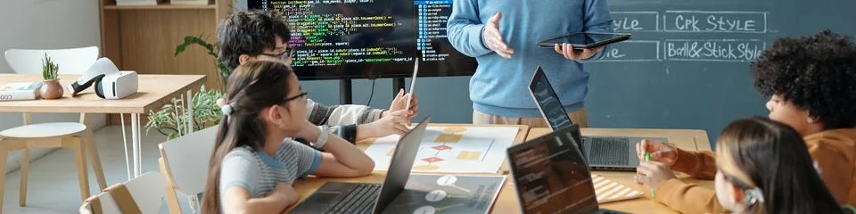 Children Attending Coding Class and Listening to Instructor Stock Photos