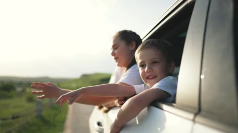Children on auto trip wave from window. Happy Children stretch hands out smiling Stock-Footage 315342184