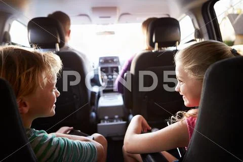 Children In Back Seat Of Car On Journey With Parents Stock Photos