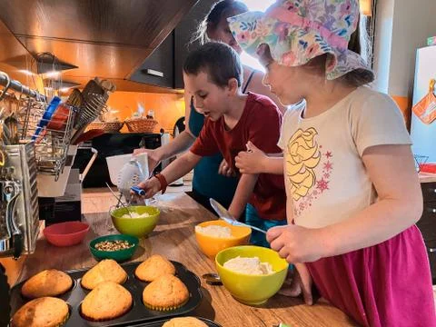 Children baking cupcakes, preparing ingredients, decorating cookies Foto stock