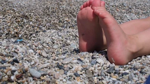 A children bare feet on a pebble beach 動画素材 281780206