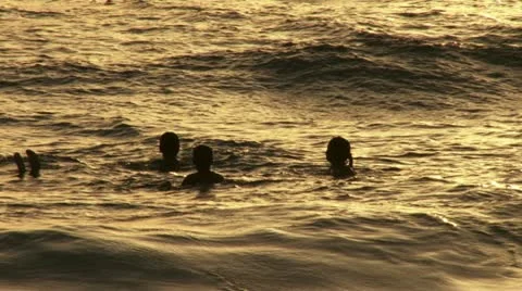 Children bathing on the sea during sunset. Silhouette. Stock Footage 20508633