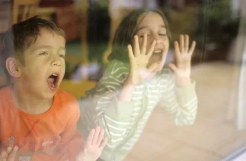 Children behind window pane Stock Photos